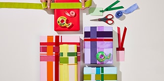 Bunt verpackte Geschenke liegen auf einem Schreibtisch
