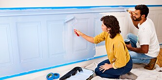 Junges Paar streicht eine Wand und verwendet Scotch® Malerabdeckband
