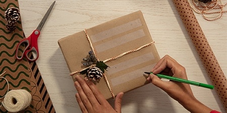Geschenketiketten mit Scotch® Magic™ Tape auf einem Geschenk, das mit einfachem Verpackungspapier verpackt ist, erstellen
