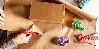 Ein minimalistisches Aussehen für eine Geschenkverpackung mit einfachem Verpackungspapier und Zuckerstangen schaffen
